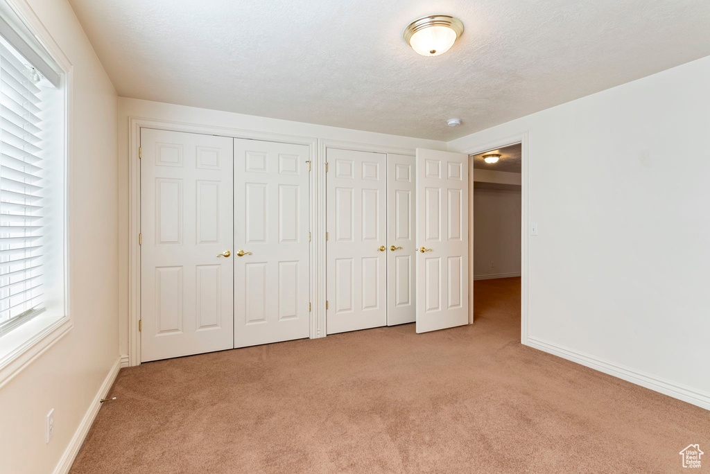 Unfurnished bedroom with two closets and carpet flooring