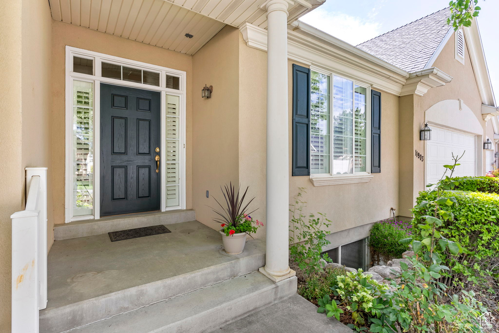 Doorway to property with a garage