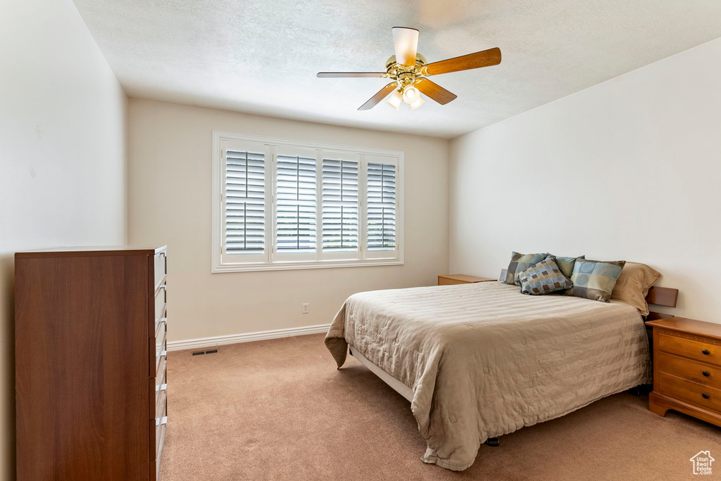 Carpeted bedroom featuring ceiling fan