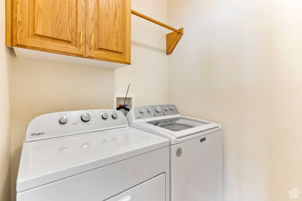 Laundry area with cabinets, hookup for a washing machine, and washing machine and clothes dryer