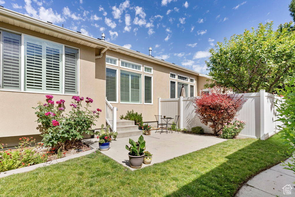 Back of property featuring a patio and a yard