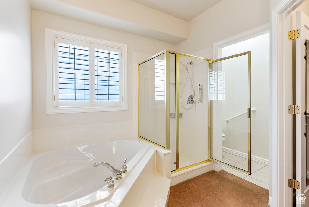 Bathroom with shower with separate bathtub, toilet, and tile floors