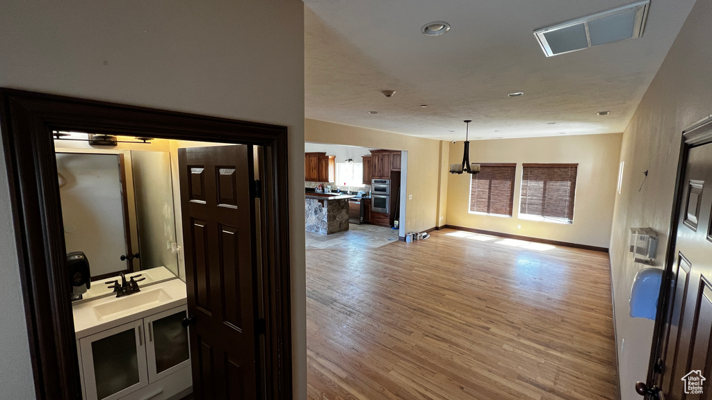 Hallway with sink and hardwood / wood-style floors