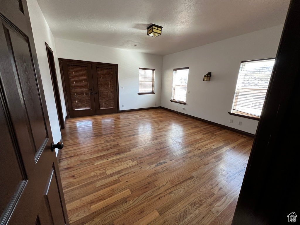 Unfurnished bedroom with hardwood / wood-style floors and french doors