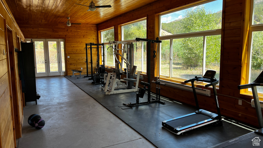 Interior space with ceiling fan, wood walls, a wealth of natural light, and wood ceiling