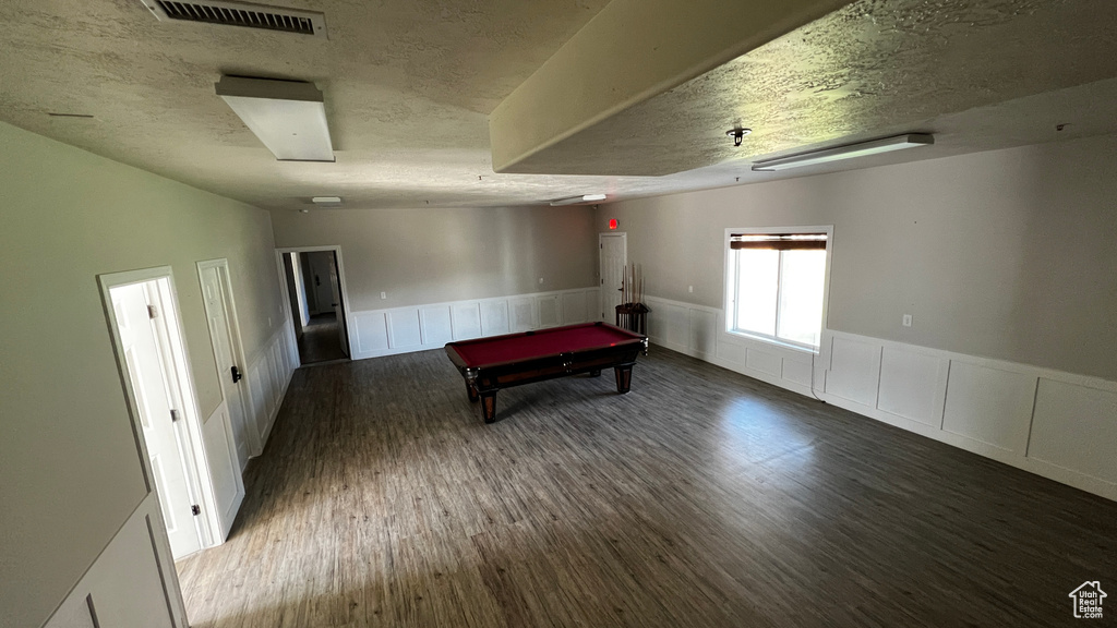 Rec room featuring dark wood-type flooring, billiards, and a textured ceiling