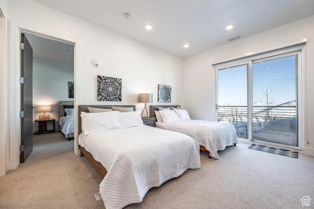 Bedroom with access to exterior and light colored carpet