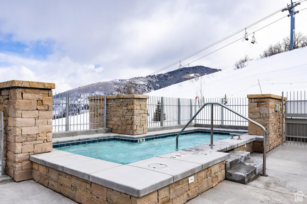 Snow covered pool with a mountain view