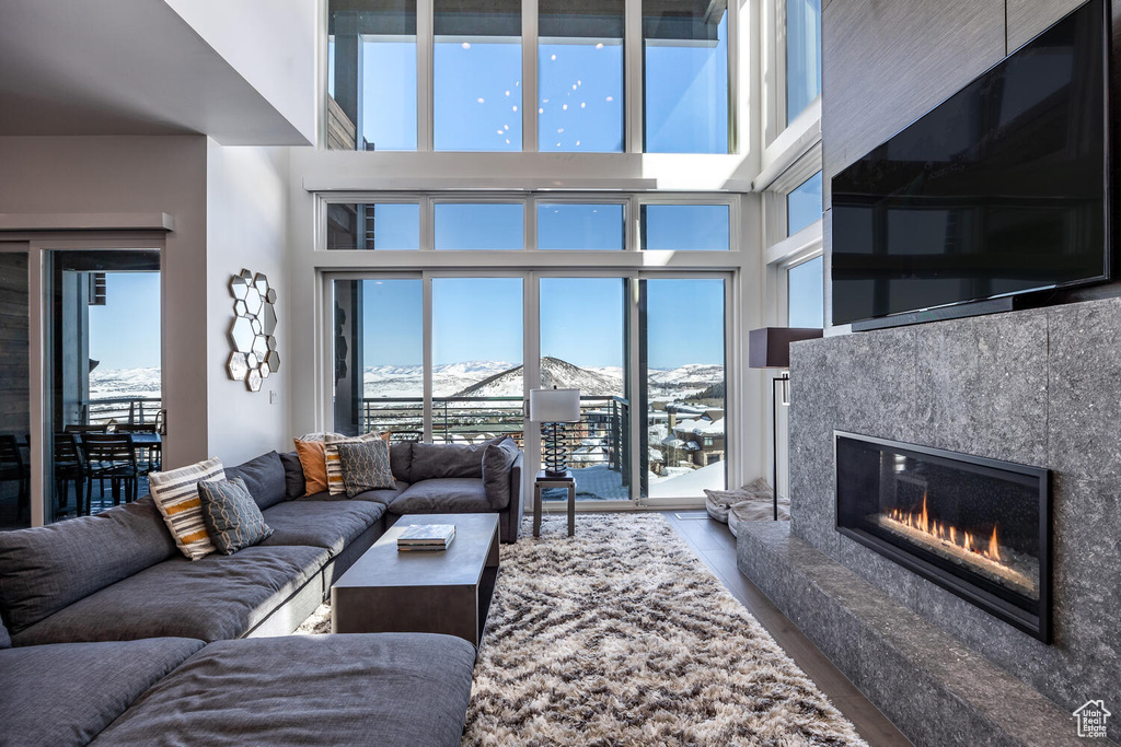 Living room featuring a premium fireplace, plenty of natural light, and a towering ceiling