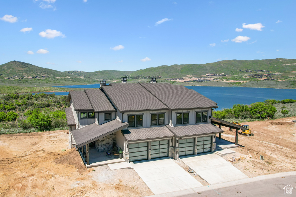 View of front of home featuring a water and mountain view and a garage