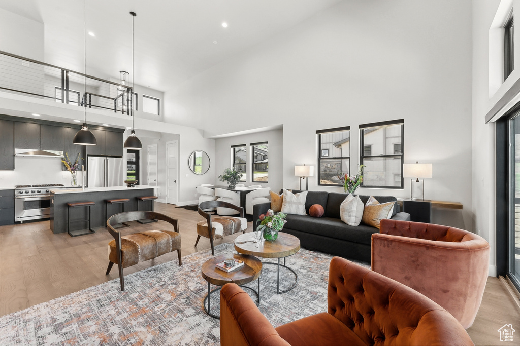 Living room featuring a towering ceiling and light hardwood / wood-style flooring