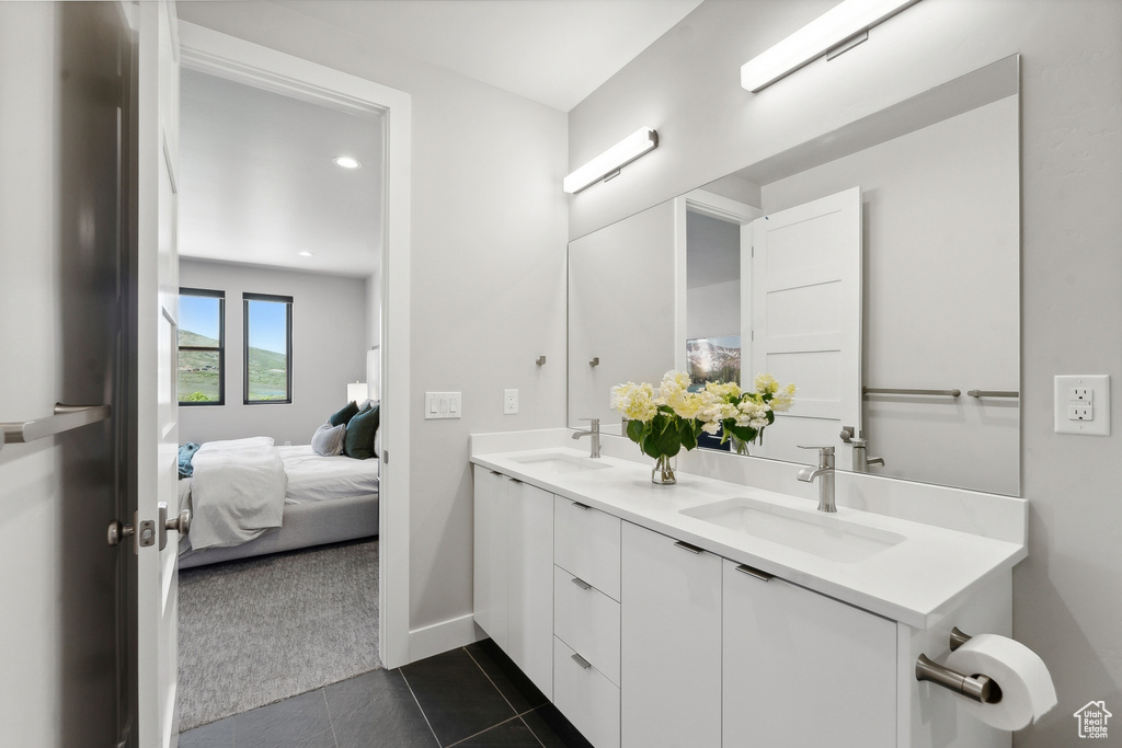 Bathroom featuring tile flooring, oversized vanity, and dual sinks