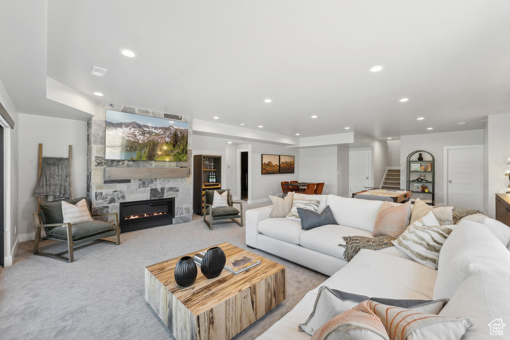 Carpeted living room featuring a tiled fireplace