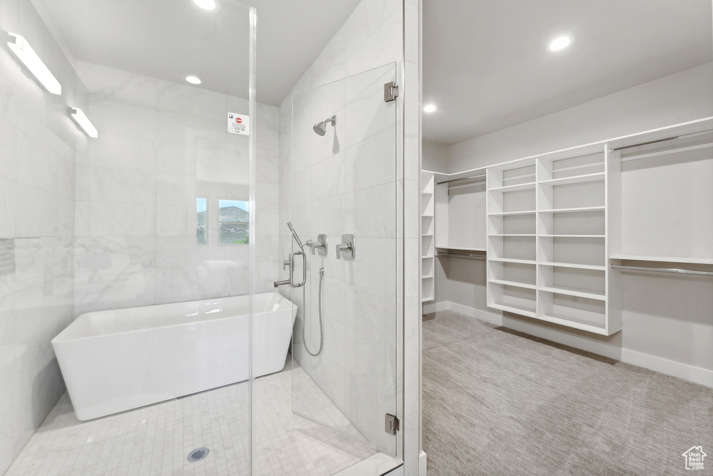 Bathroom featuring tile walls and independent shower and bath