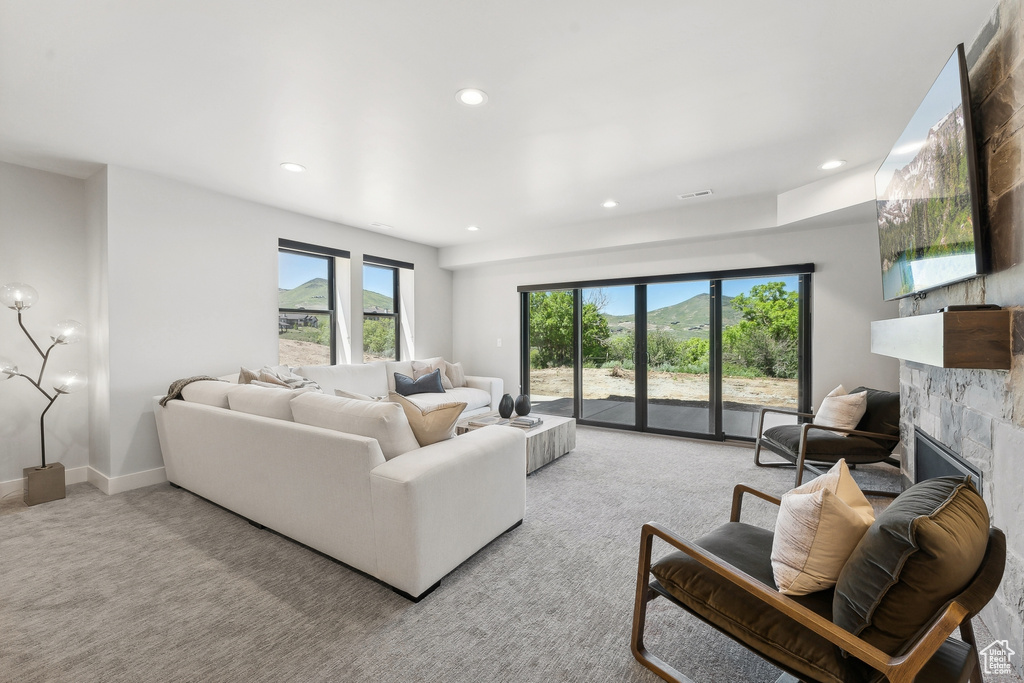 Carpeted living room featuring a tiled fireplace