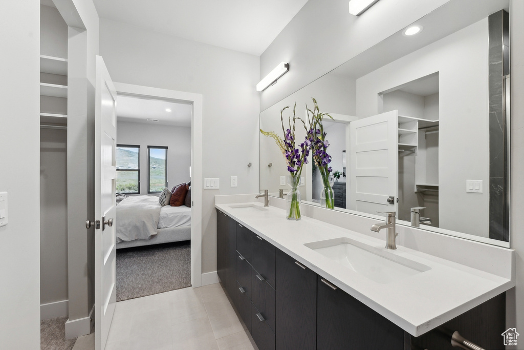 Bathroom with tile flooring, oversized vanity, and double sink