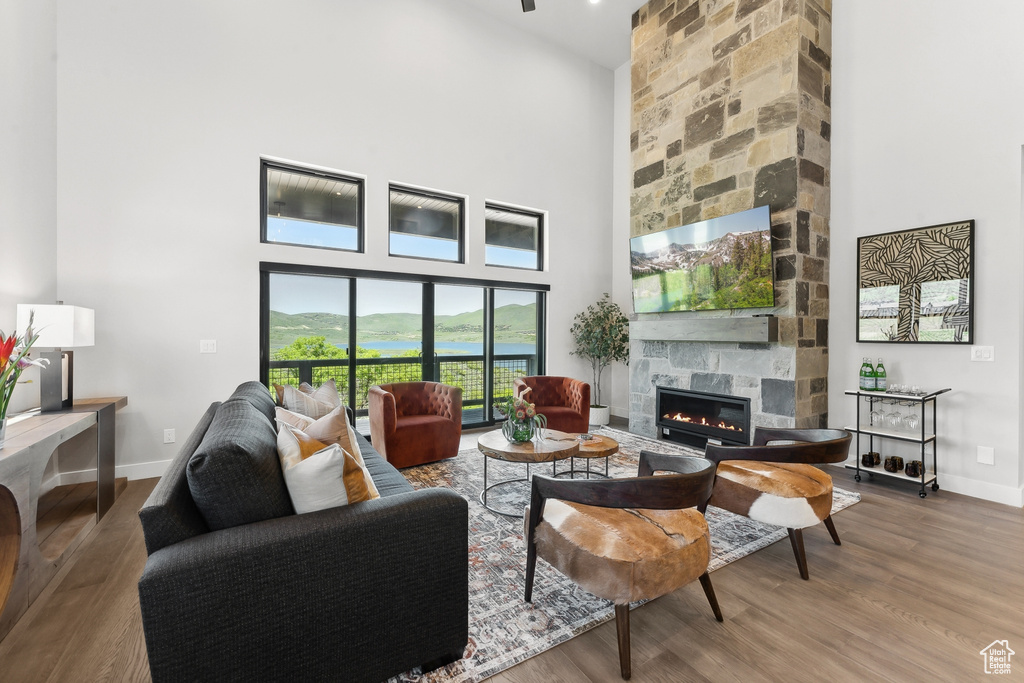 Living room with a high ceiling, hardwood / wood-style flooring, and a water view