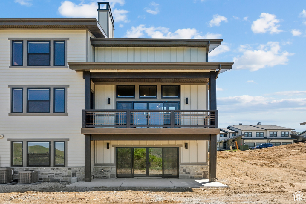 Rear view of property with central AC unit and a balcony