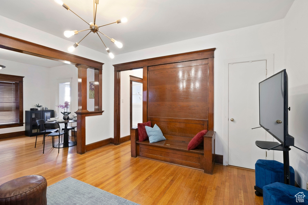 Interior space featuring a notable chandelier, light hardwood / wood-style flooring, and ornate columns