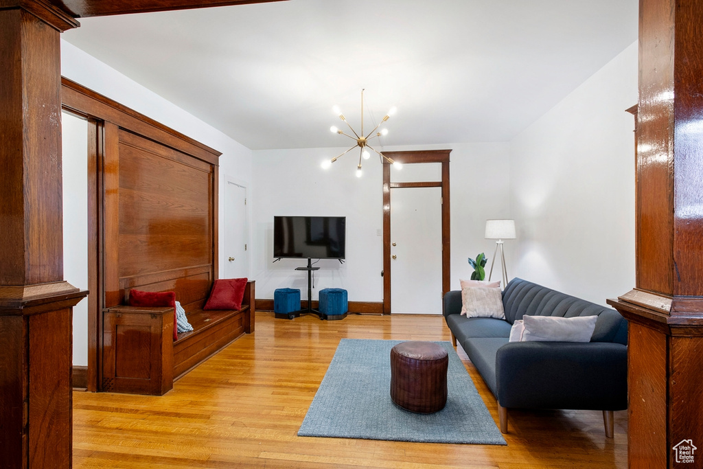 Living room with an inviting chandelier and light hardwood / wood-style floors