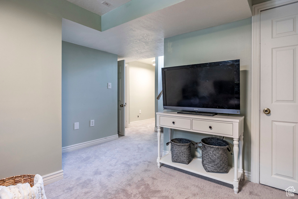 Interior space with light carpet and a textured ceiling