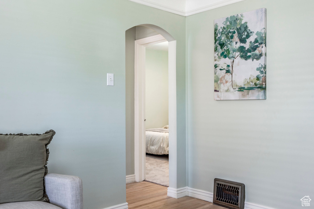 Living area with ornamental molding and light wood-type flooring