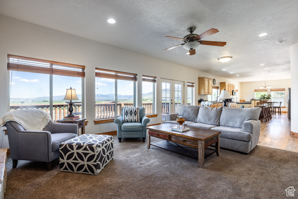 Living room with ceiling fan and hardwood / wood-style floors