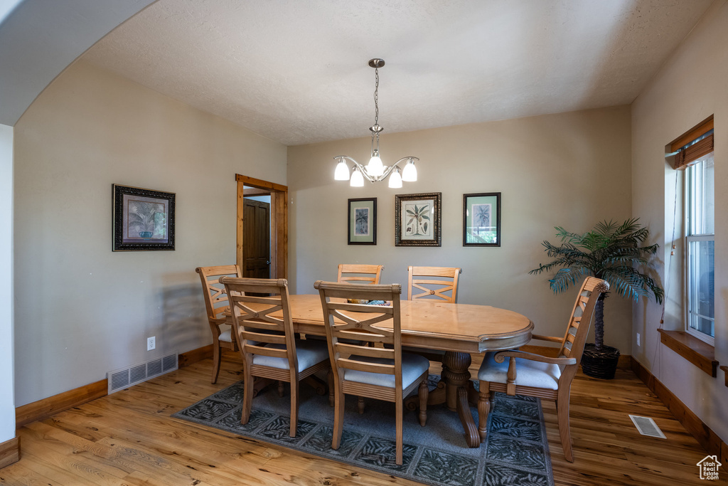 Dining space with hardwood / wood-style flooring and a chandelier