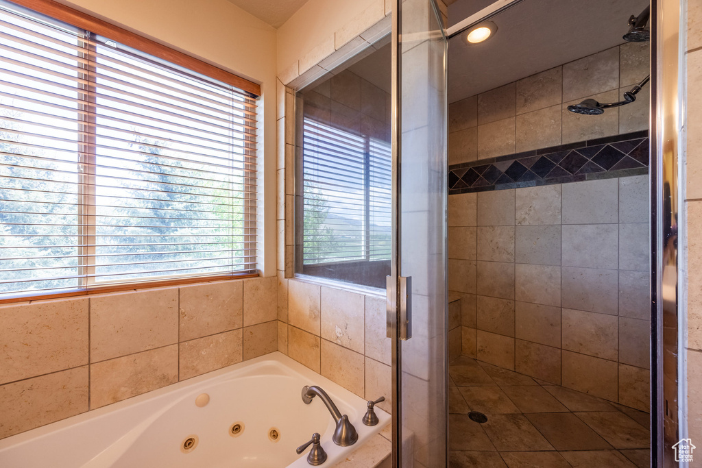 Bathroom featuring a shower with door and a healthy amount of sunlight