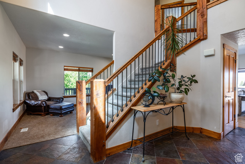 Stairs with dark tile patterned floors