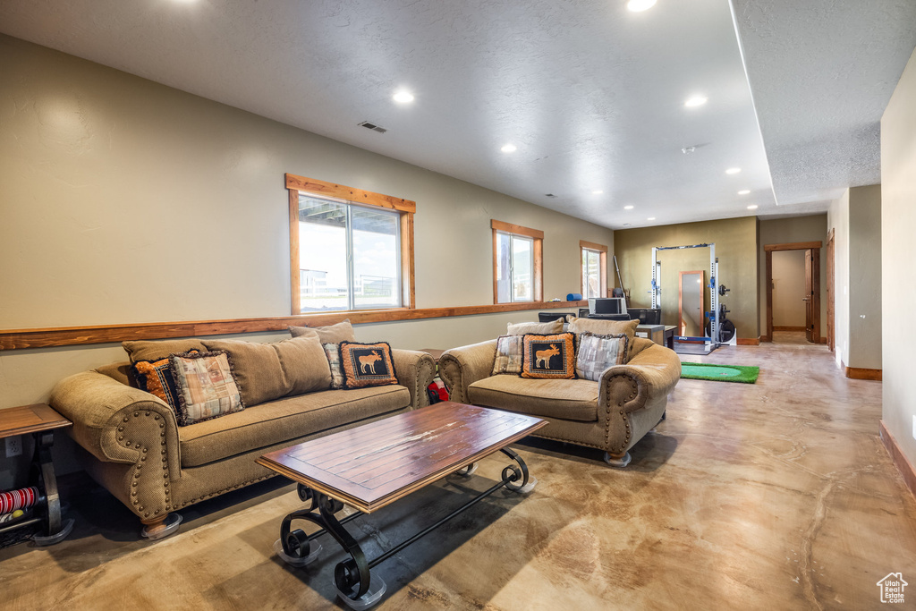 Living room with concrete floors and a textured ceiling