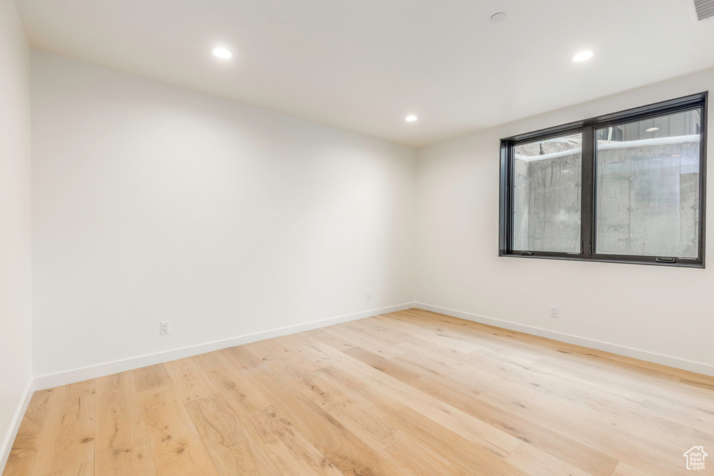 Empty room featuring recessed lighting, light wood-style flooring, and baseboards