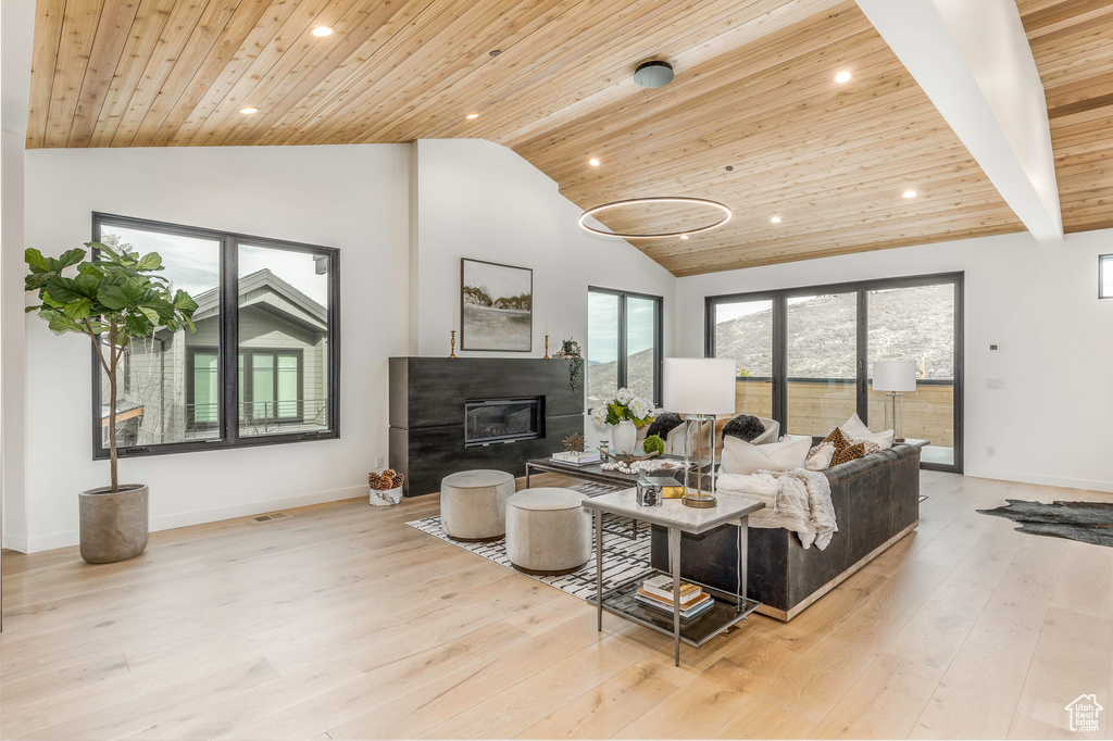 Living area featuring baseboards, light wood finished floors, recessed lighting, and wood ceiling