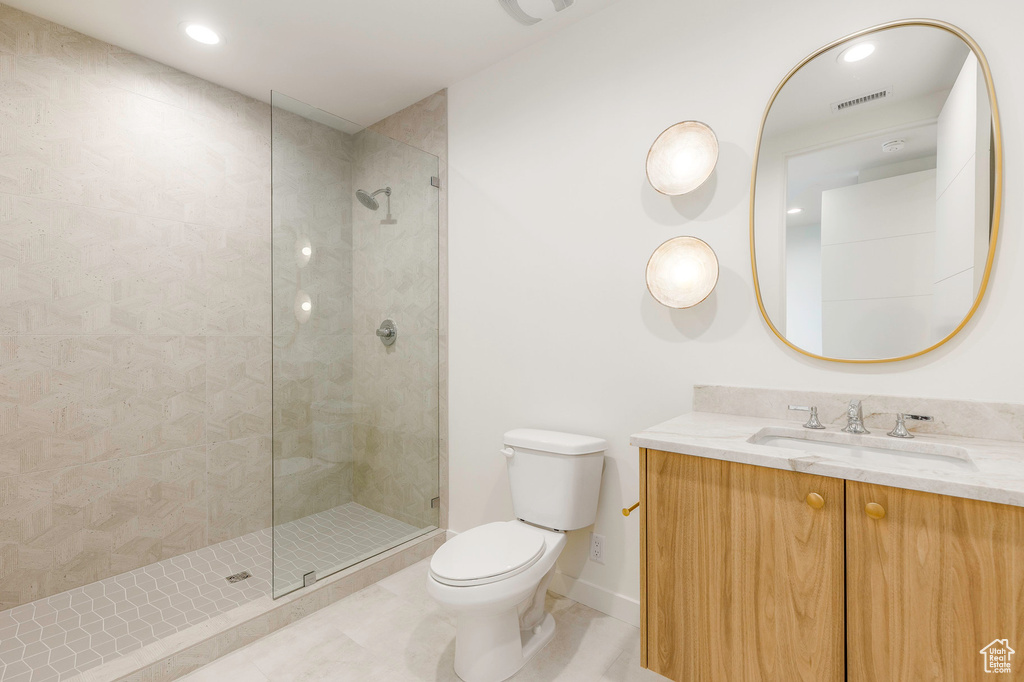 Full bathroom featuring visible vents, toilet, vanity, tiled shower, and tile patterned flooring