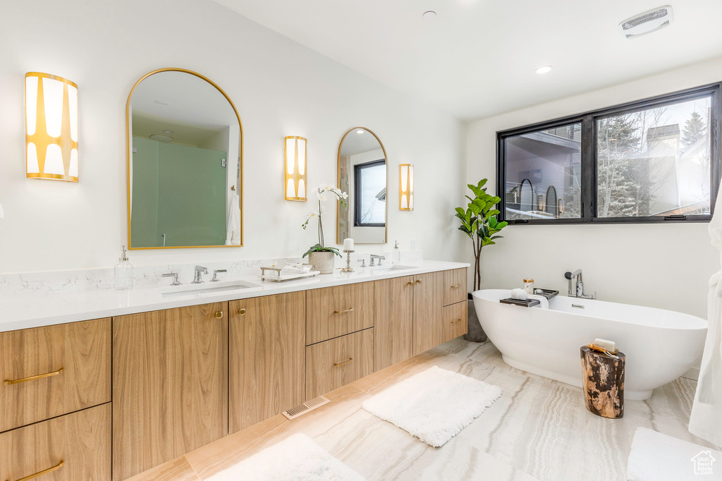 Bathroom with a freestanding bath, double vanity, and a sink