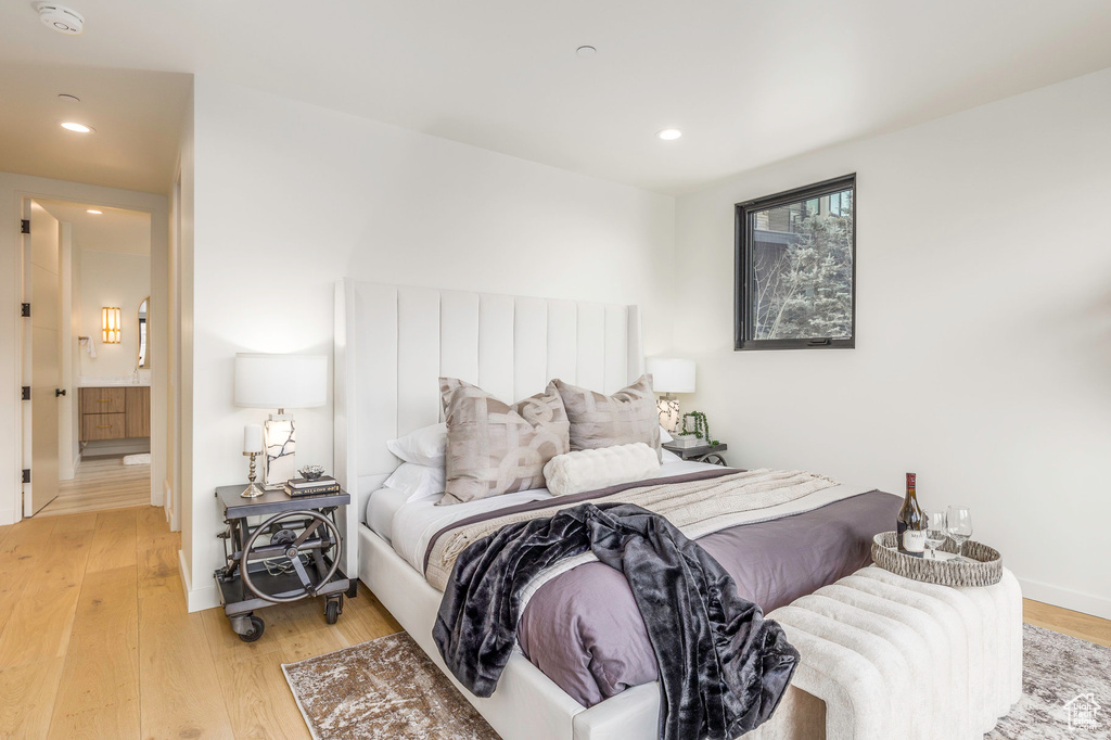 Bedroom with light wood finished floors, baseboards, and recessed lighting