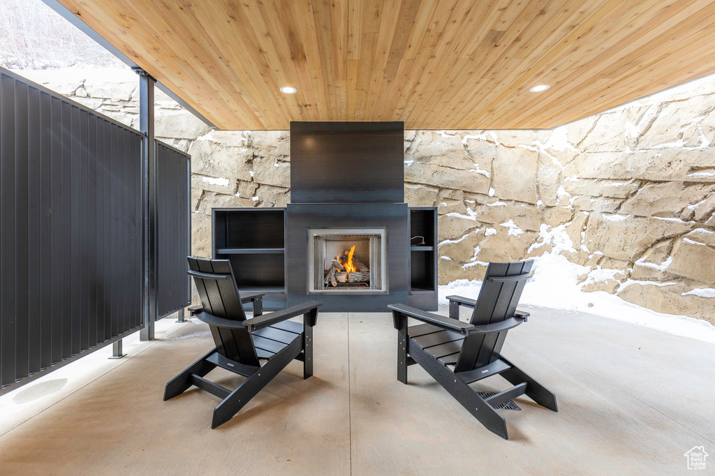 View of patio / terrace featuring a warm lit fireplace