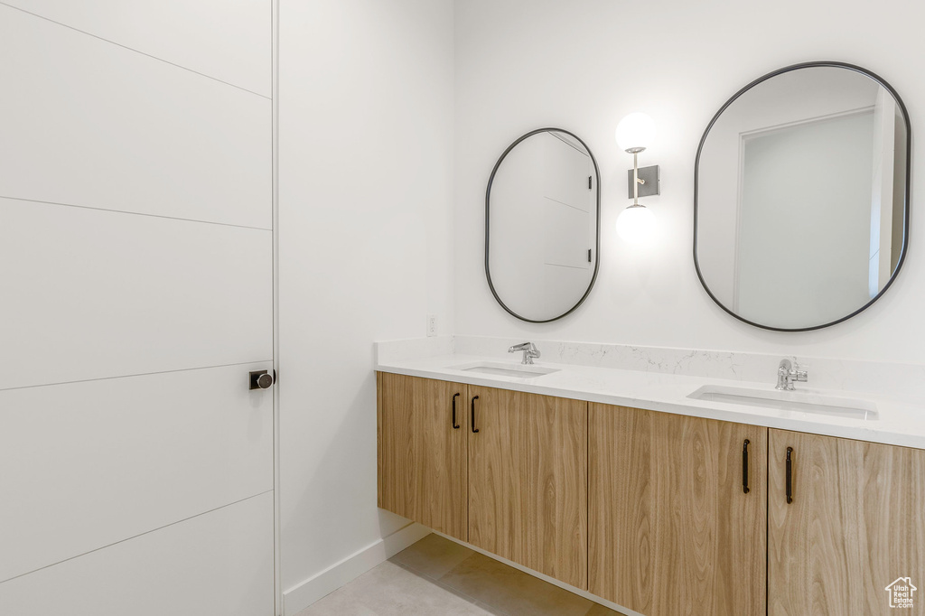 Full bath featuring double vanity and a sink