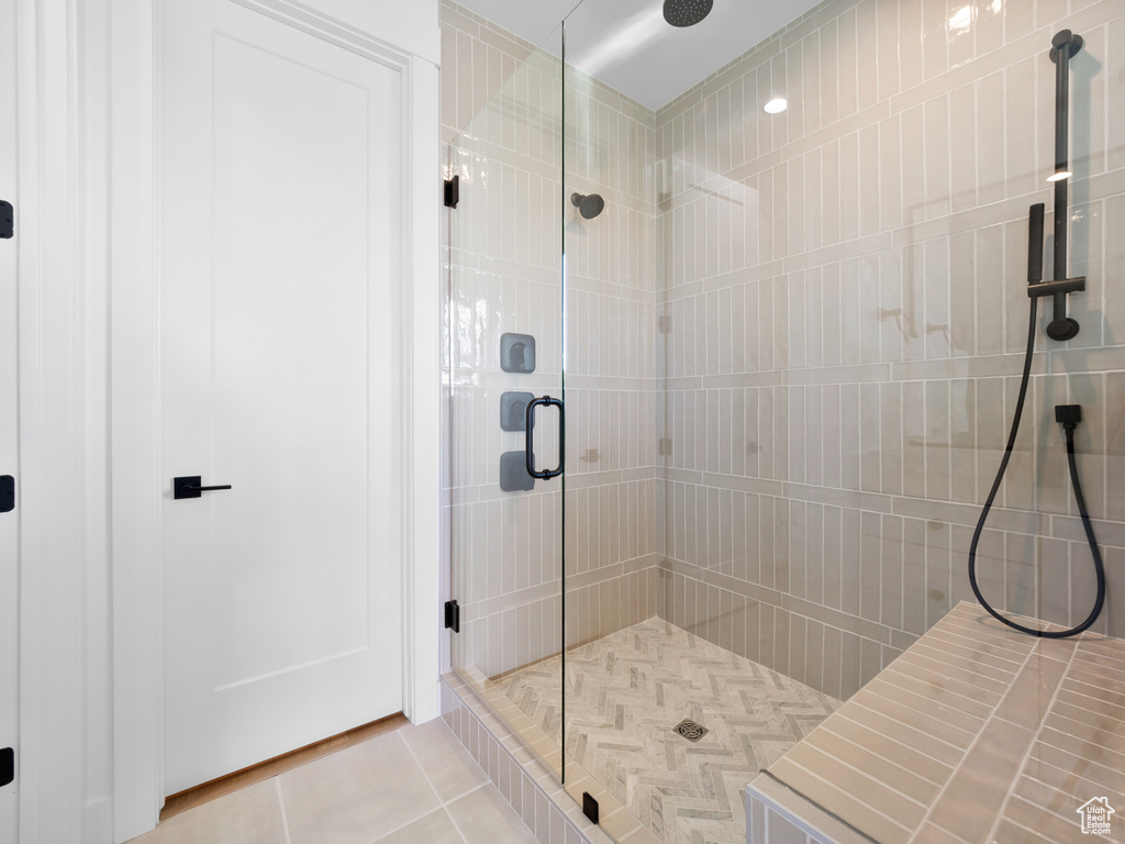 Bathroom featuring tile patterned flooring and a shower with door