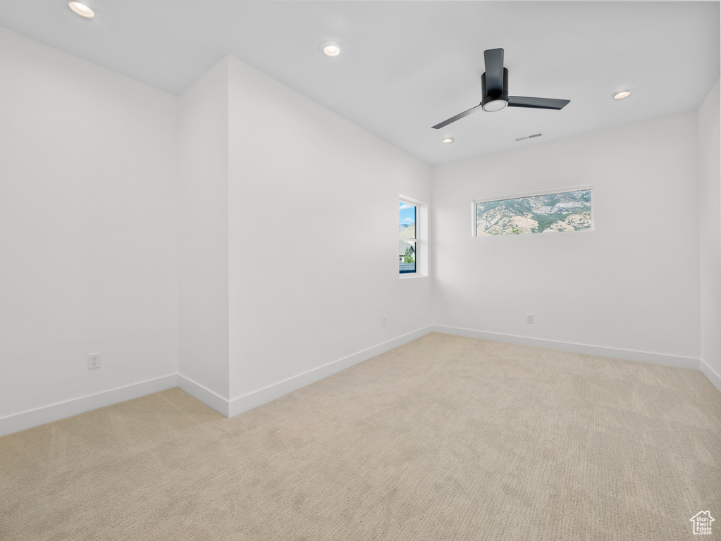 Spare room with ceiling fan and light colored carpet