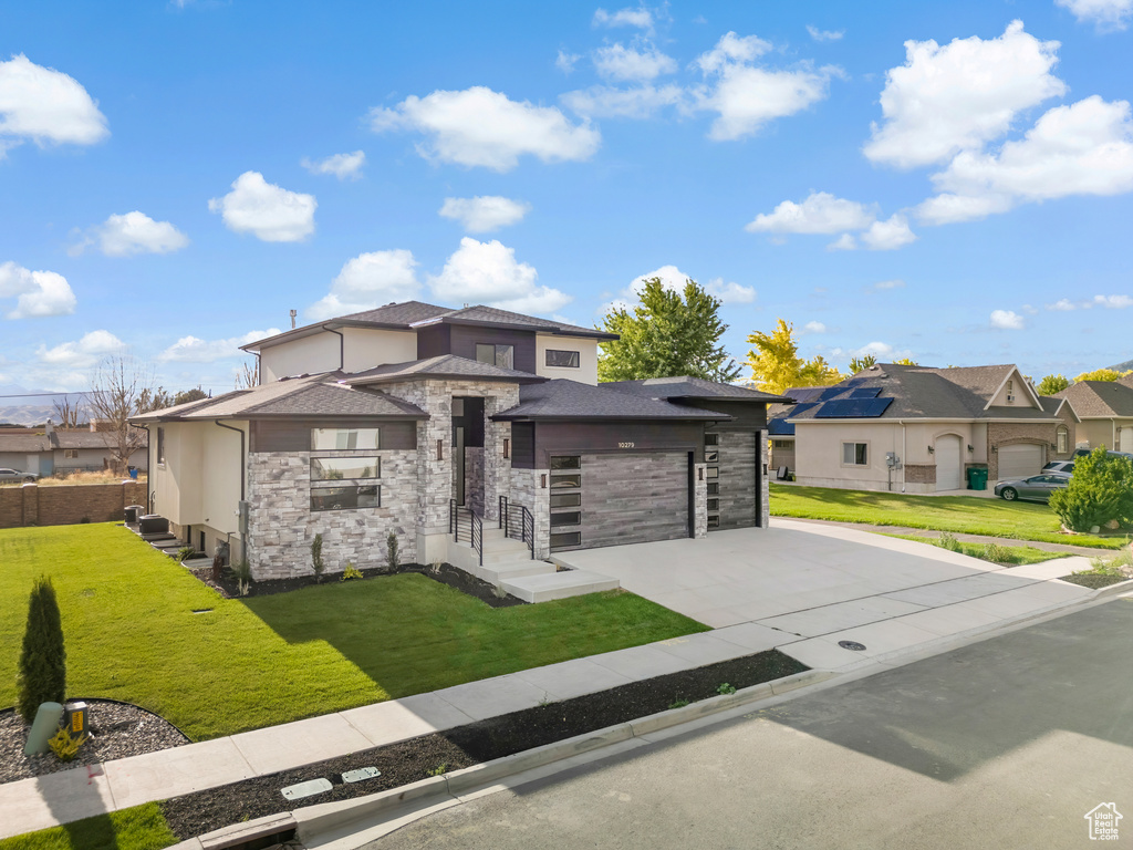 Prairie-style house featuring a front yard and a garage