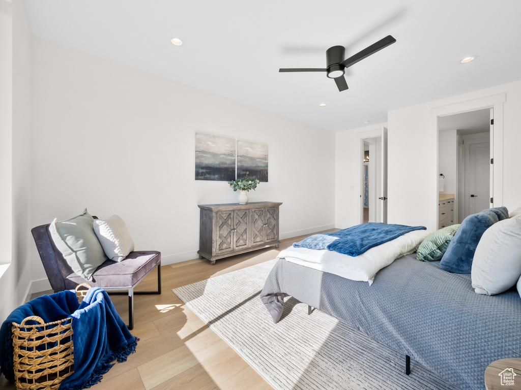 Bedroom featuring light hardwood / wood-style flooring, ceiling fan, and ensuite bathroom