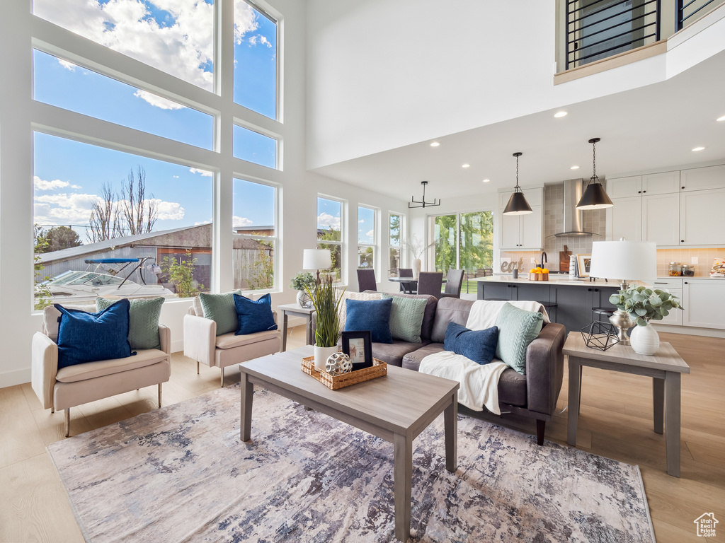 Living room with light hardwood / wood-style floors and a high ceiling