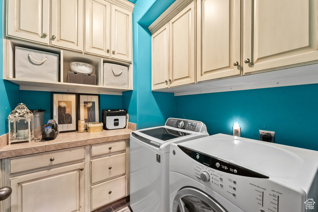 Washroom featuring cabinets, electric dryer hookup, and washing machine and clothes dryer