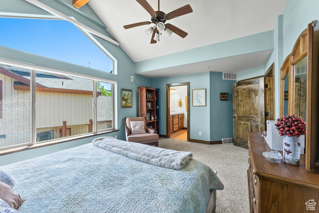 Carpeted bedroom featuring high vaulted ceiling, ceiling fan, and connected bathroom