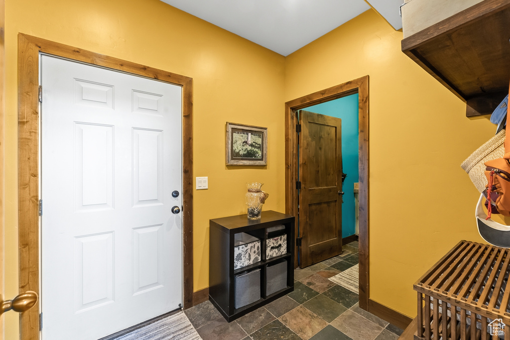 Foyer featuring dark tile flooring