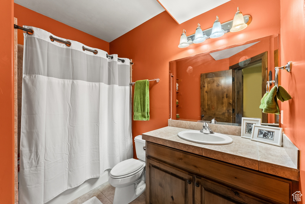 Bathroom featuring tile floors, vanity with extensive cabinet space, and toilet