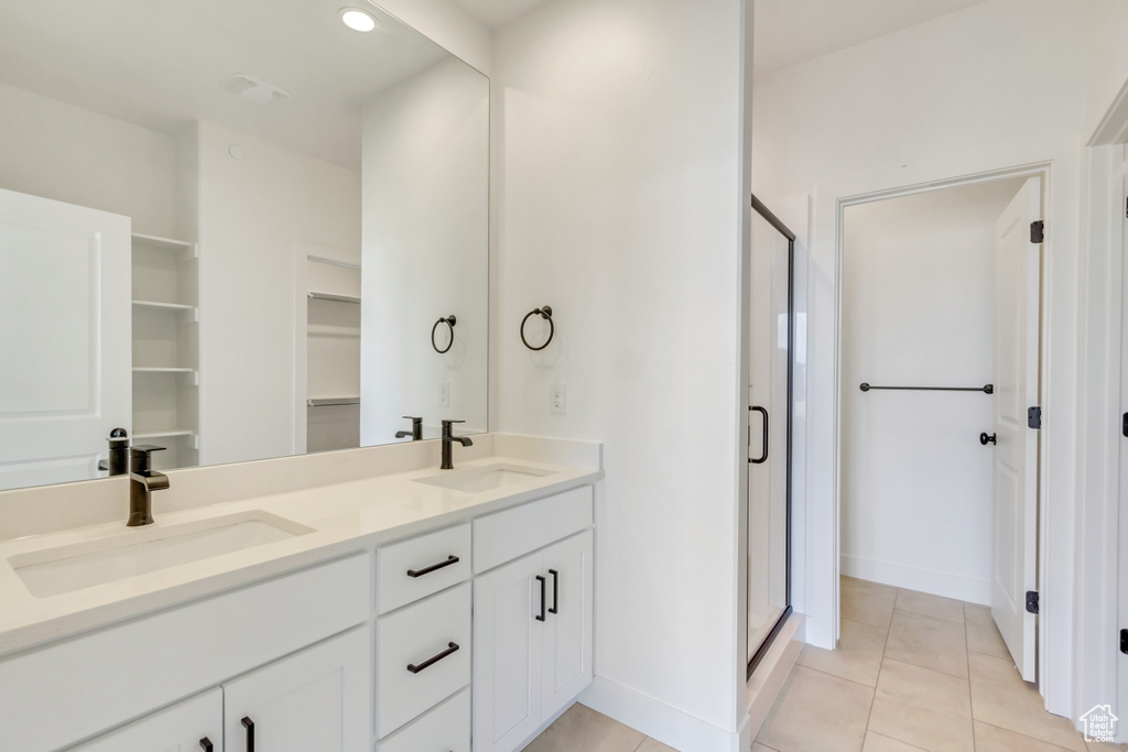 Bathroom featuring a shower with door, tile patterned flooring, and vanity