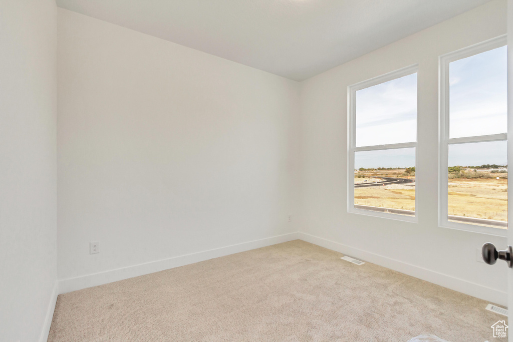 Unfurnished room featuring light carpet