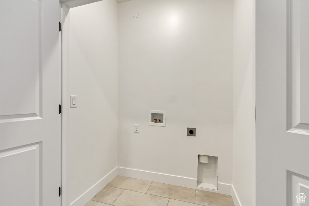 Laundry area with electric dryer hookup, washer hookup, and light tile patterned floors